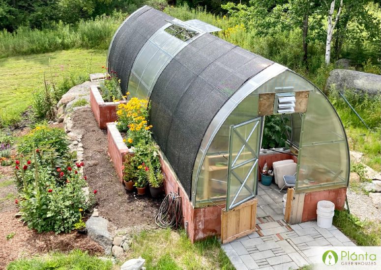 Polycarbonate greenhouse with open roof vent for humidity control