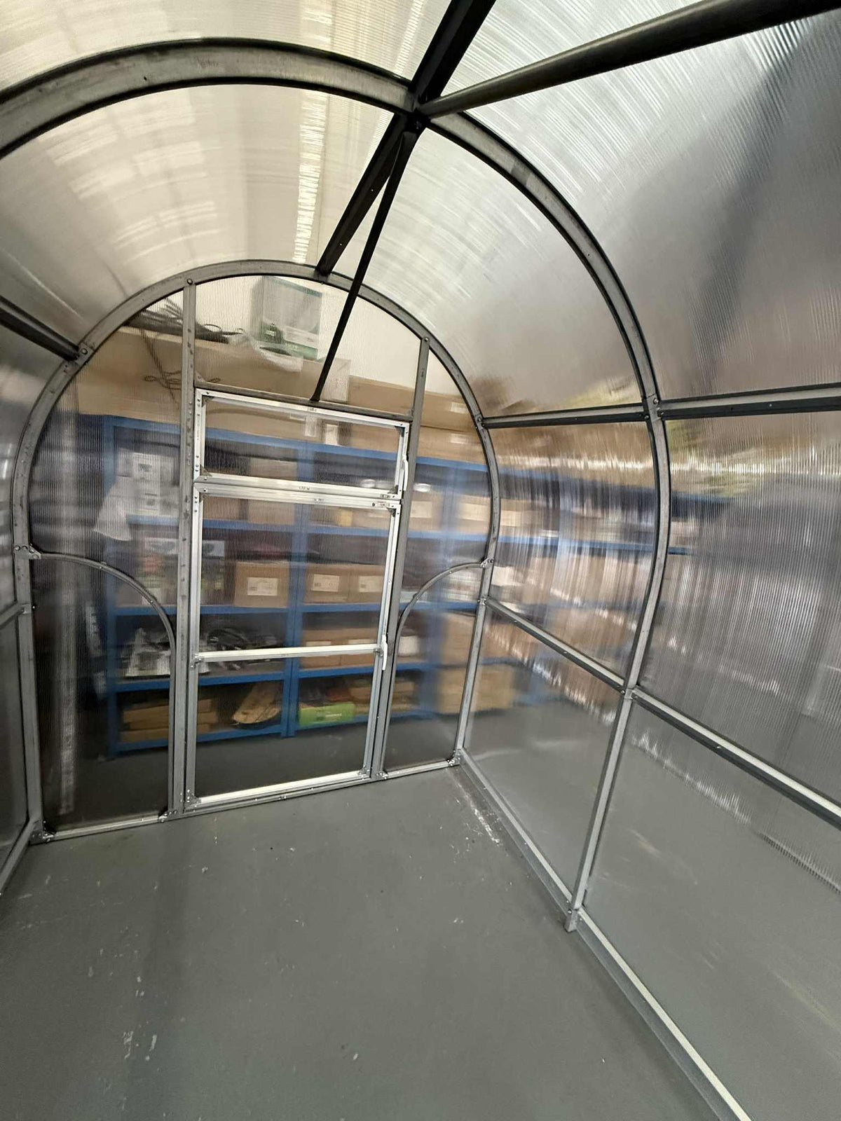 Interior of a Sigma 200 (Gen III) greenhouse with shelves and a ladder.