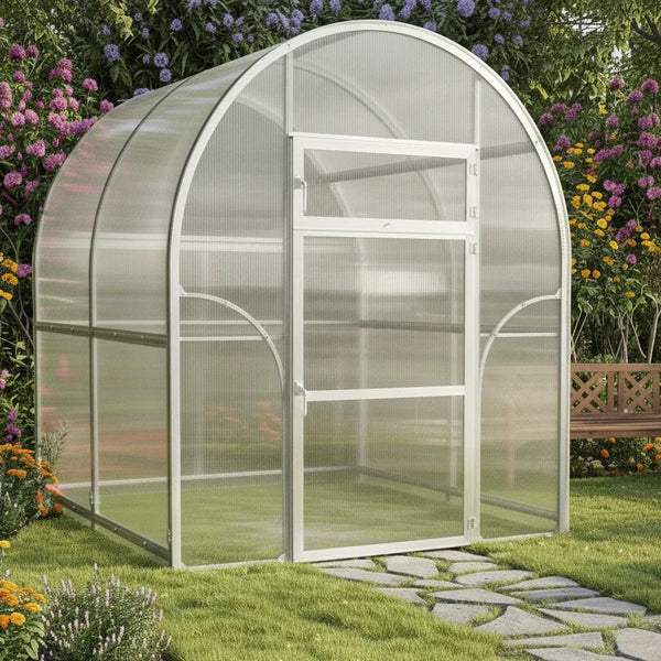 Arch-shaped Sigma 2x4 (Gen III) greenhouse in a garden with flowers and a stone path by Planta Greenhouses EU.