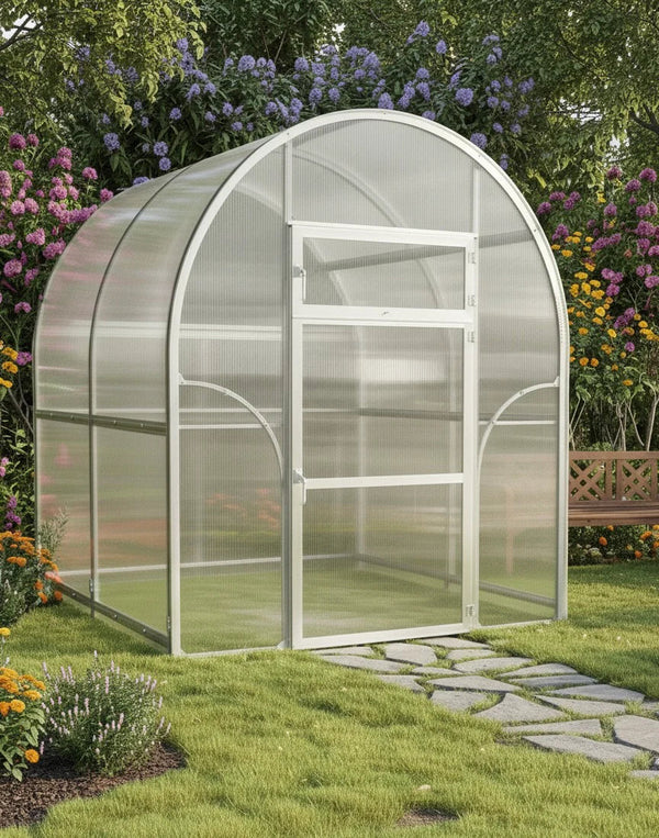 Arch-shaped Sigma 2x4 (Gen III) greenhouse in a garden with flowers and a stone path by Planta Greenhouses EU.