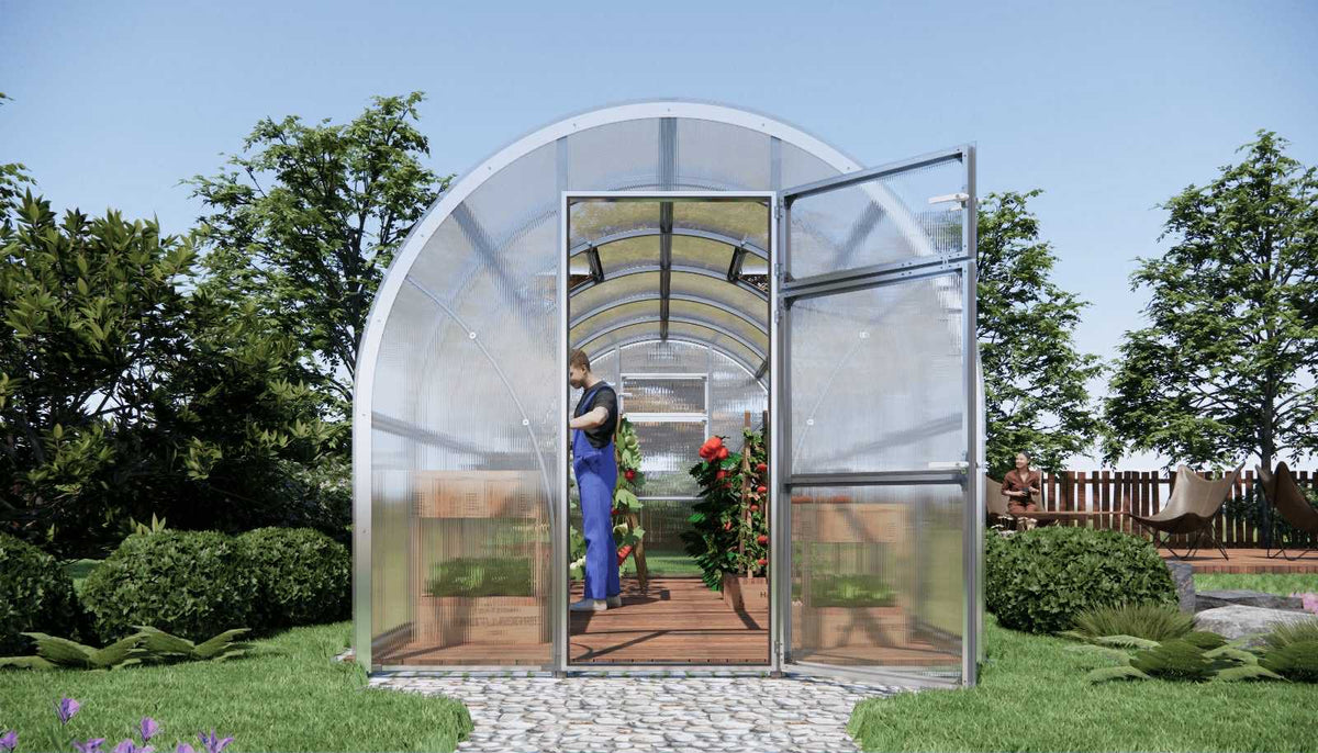 Arc-shaped Sigma 250 (Gen III) greenhouse with a person inside, surrounded by trees and greenery.