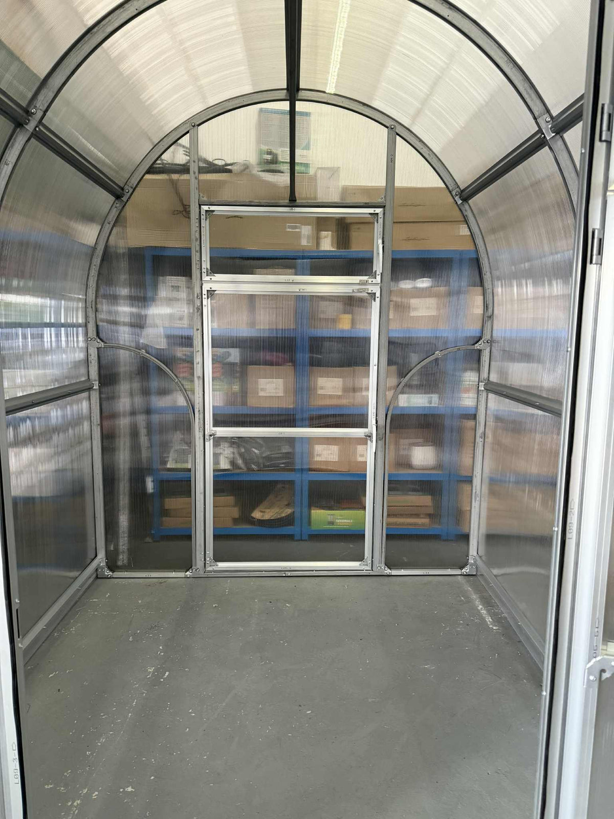 Interior of a Sigma 20 (Gen III) greenhouse with transparent walls and a door.